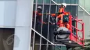 Pekerja dengan perlengkapan keselamatan kerja membersihkan kaca gedung di kawasan Kuningan, Jakarta, Selasa (3/6). Menaker Hanif Dhakiri mengatakan angka kecelakaan kerja secara nasional masih sangat tinggi. (Liputan6.com/Helmi Afandi)