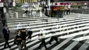 Penumpang tercermin di jendela bus saat mereka menyeberang jalan di Tokyo, Kamis (15/7/2021). Olimpiade Tokyo 2020 yang tertunda pandemi corona dibuka pada 23 Juli tanpa penonton di sebagian besar tempat. (AP Photo /Jae C.Hong)