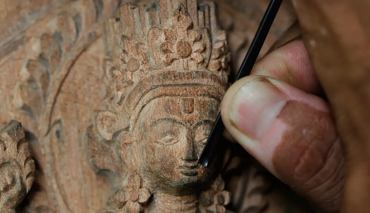 Pengrajin kayu mengukir detail dari kayu di Lalitput, Nepal (19/7). Komuitas pengrajin kayu ini memulai aktivitas sosialnya sejak dua tahun lalu. (AP Photo/Niranjan Shrestha)