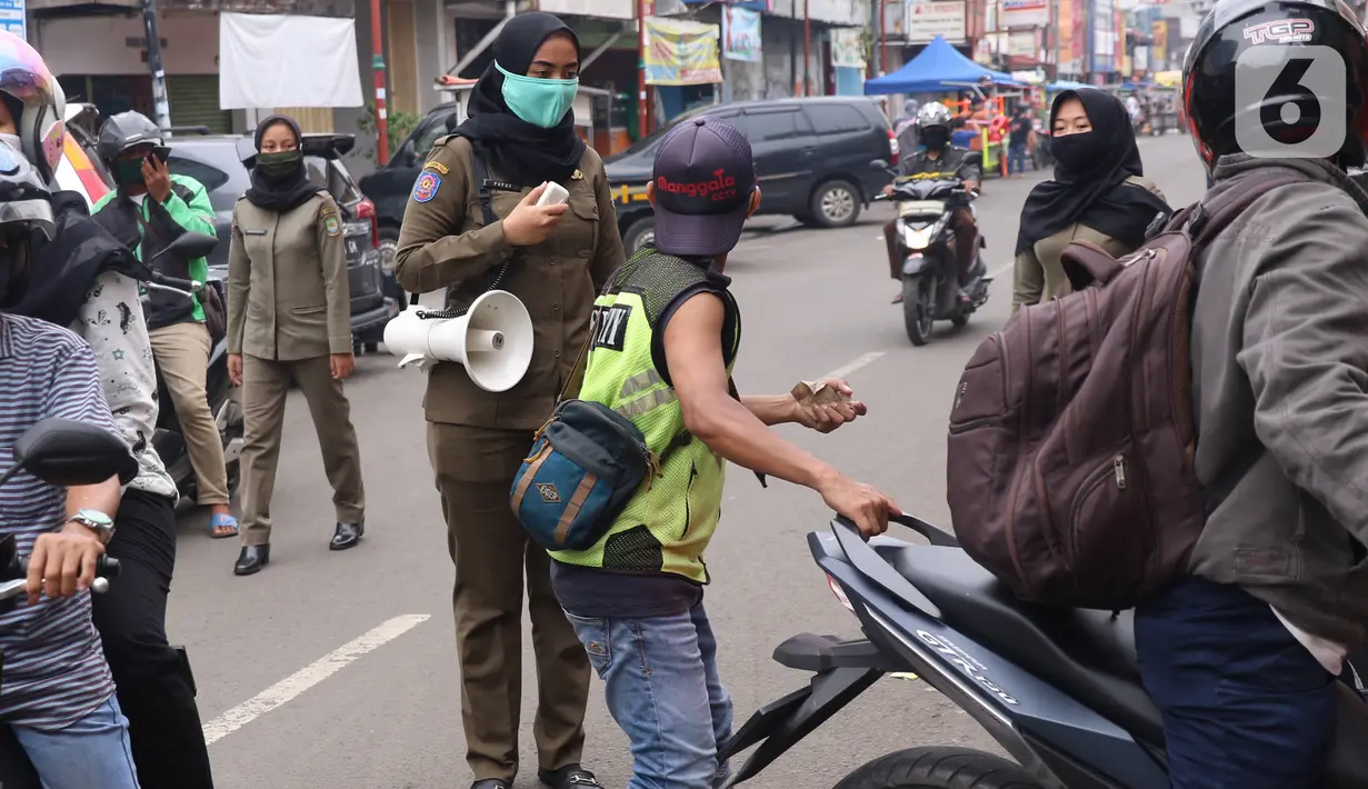 Petugas Satpol PP mengimbau warga untuk menggunakan masker dan menjaga jarak di Pasar Lama, Kota Tangerang, Banten, Sabtu (9/6/2020). Pemkot Tangerang melakukan penegasan pada PSBB tahap dua dengan menugaskan petugas di keramaian guna memutus rantai penyebaran COVID-19.  (Liputan6.com/Angga Yuniar)