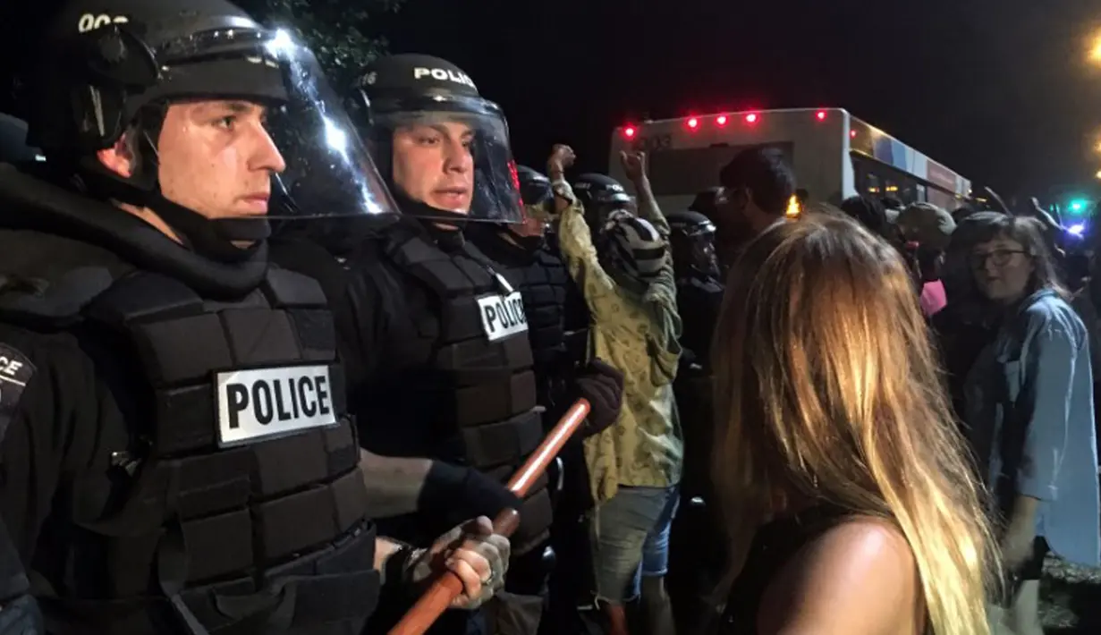 Pengunjuk rasa meluapkan kemarahannya kepada petugas kepolisian yang berjaga di lokasi unjuk rasa di Charlotte, North Carolina, AS, Selasa (20/9). Polisi akhirnya mengeluarkan gas air mata untuk membubarkan massa. (REUTERS/Adam Rhew)