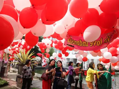 Komunitas Perempuan Peduli Kota Jakarta (PPKJ) membawa ribuan balon merah putih ke halaman Balai Kota DKI Jakarta, Senin (8/5). Balon-balon itu pun menjadi daya tarik bagi warga yang hari ini berkunjung ke Balai Kota. (Liputan6.com/Faizal Fanani)