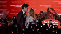 Pemimpin Partai Liberal, Justin Trudeau mencium istrinya Sophie Gregoire usai pemilihan umum di Montreal, Quebec, Kanada, Senin (19/10). Trudeau mengakhiri kekuasaan sembilan tahun PM Stephen Harper dari Partai Konservatif. (Reuters/ Chris Wattie)