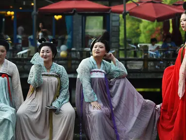 Empat wanita berpose mengenakan kostum Dinasti Tang saat mengunjungi Danau Barat di Hangzhou di provinsi Zhejiang timur China (31/3). Bahan pakaian Dinasti Tang terbuat dari sutra dan terkenal karena kelembutan dan ringan.  (AFP Photo/China Out)