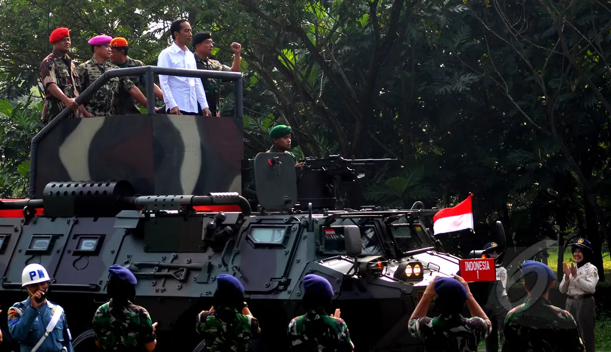 Presiden Joko Widodo saat menaiki Panser Anoa ditemani panglima TNI Jenderal Moeldoko dan Para Kepala Kesatuan jelang upacara pengangkatan dirinya sebagai warga kehormatan pasukan khusus TNI, Kamis (16/4/2015). (Liputan6.com/Yoppy Renato)