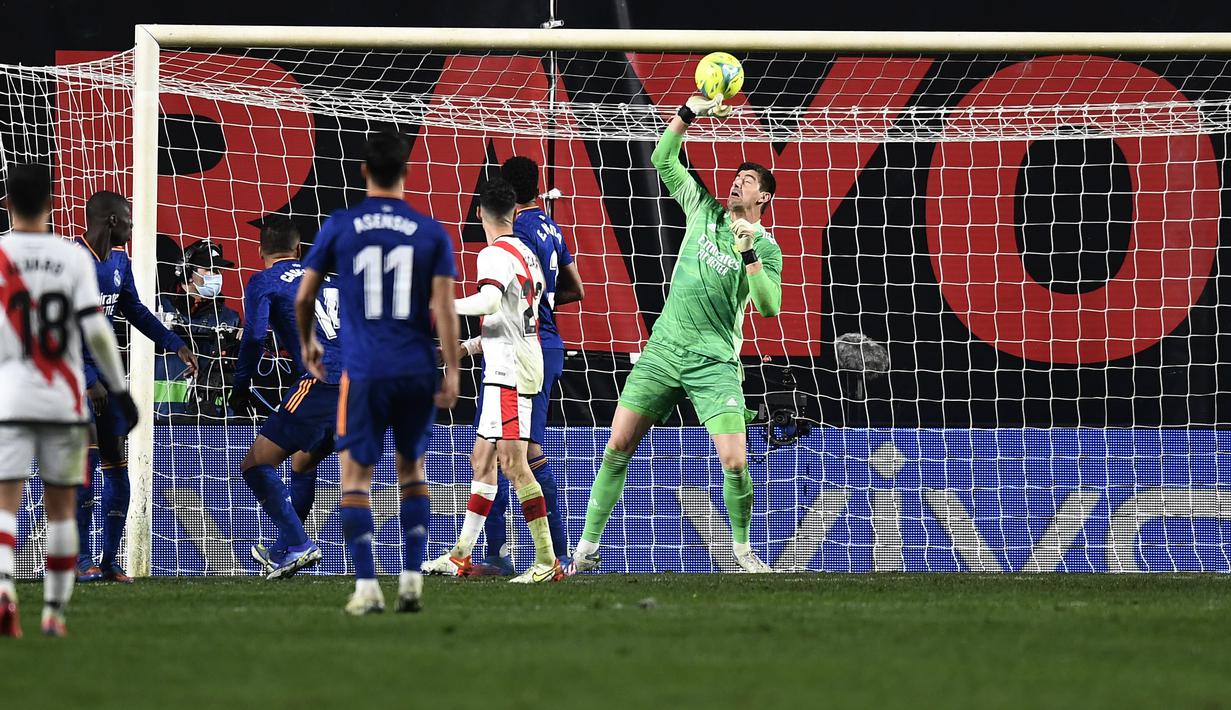 Penjaga gawang Real Madrid, Thibaut Courtois melakukan penyelamatan saat bertanding melawan Rayo Vallecano pada pertandingan La Liga Spanyol di stadion Vallecas di Madrid, Spanyol, Minggu (27/2/2022). Real Madrid menang tipis atas Rayo Vallecano 1-0. (AP Photo/Jose Breton)