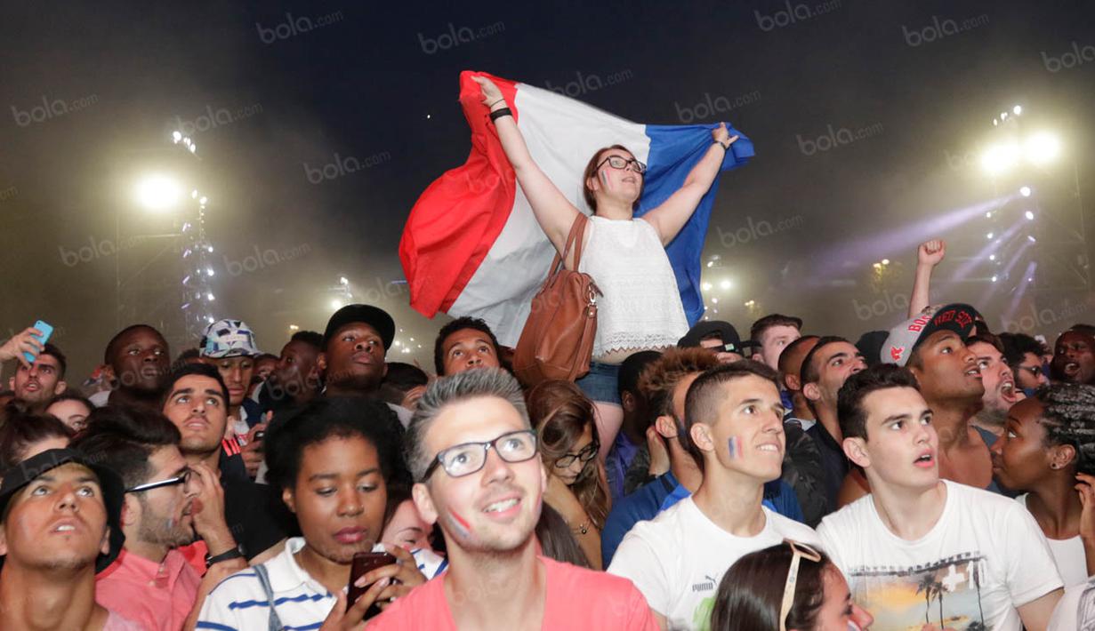 Sambil mengangkat bendera, warga Prancis merayakan kemenangan dengan skor 2-0 atas Jerman. (Bola.com/Vitalis Yogi Trisna)