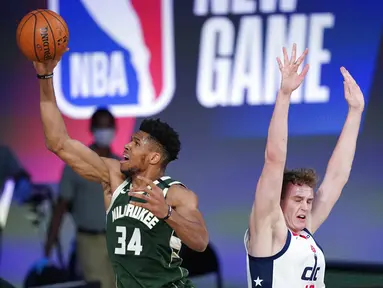 Pebasket Milwaukee Bucks, Giannis Antetokounmpo, berusaha memasukkan bola saat melawan Washington Wizards pada laga NBA, Selasa (11/8/2020). Bucks mengalahkan Wizards dengan skor 126-113. (AP Photo/Ashley Landis, Pool)
