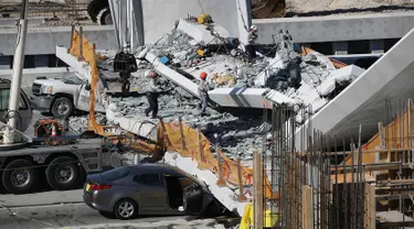 Tim Penyelamatan Kebakaran Miami-Dade Fire dan unit penyelamatan lainnya berusaha mengevakuasi korban runtuhnya jembatan pejalan kaki di Miami, Florida (15/3). Beberapa orang dilaporkan tewas dalam insiden ini. (Joe Raedle / Getty Images / AFP)