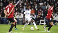 Pemain Real Madrid Vinicius Junior mencoba menerobos pertahanan Osasuna saat pertandingan La Liga Spanyol di Santiago Bernabeu, Madrid, Kamis (28/10/2021) dini hari WIB. (AP Photo/Jose Breton)