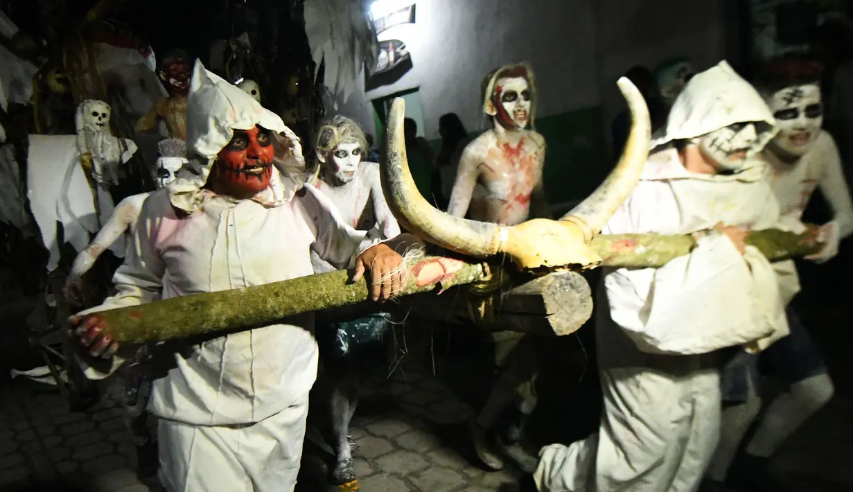 Sejumlah peserta mengenakan kostum hantu menggelar pawai dalam parade La Calabiuza di Tonacatepeque, El Salvador (1/11). Selama perayaan, penduduk Tonacatepeque mengingat kembali karakter dari mitologi Cuscatlan. (AFP Photo/Marvin Recinos)