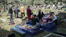 Sejumlah umat muslim menaburkan bunga di makam keluarganya di Tempat Pemakaman Umum (TPU) Karet Tengsin, Jakarta, Minggu (27/3/2022). Sepekan jelang datangnya bulan suci Ramadan, banyak warga yang melakukan tradisi ziarah makam untuk mendoakan keluarganya. (Liputan6.com/Faizal Fanani)