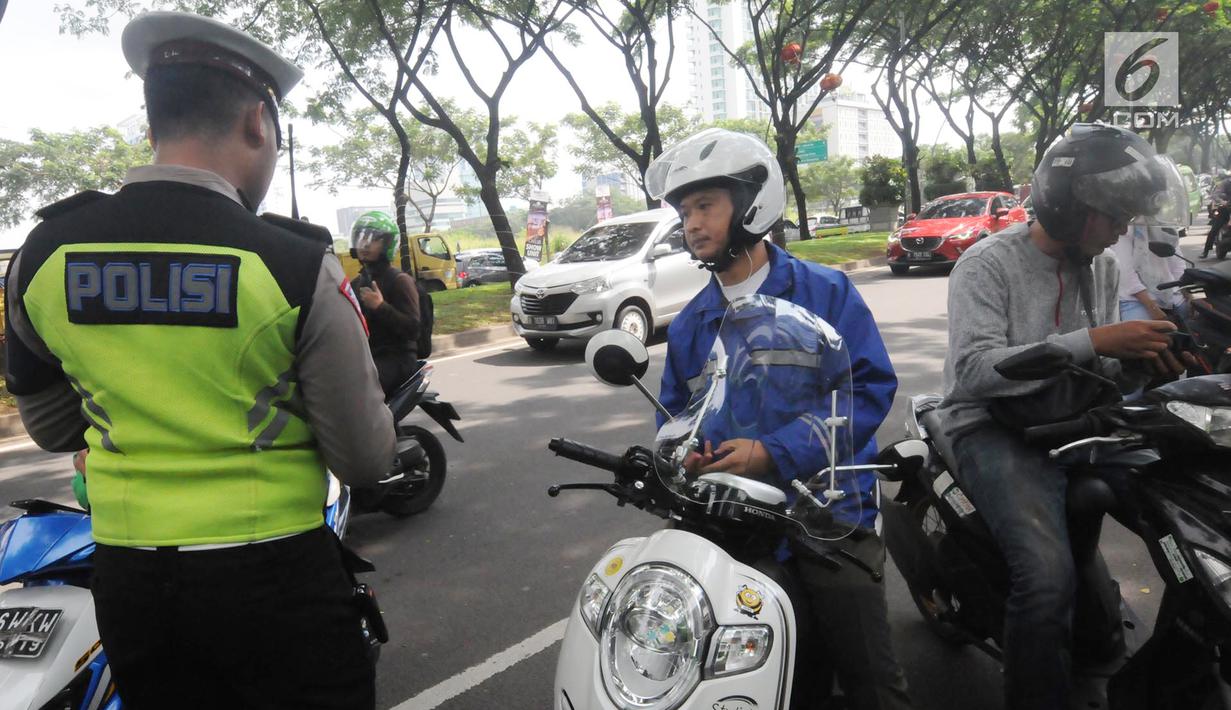 Anggota Satlantas Polres Tangerang Selatan memeriksa kelengkapan surat saat razia pajak kendaraan di Jalan BSD, Tangerang Selatan, Kamis (24/1). Razia ini untuk mendisiplinkan pengendara terhadap pembayaran pajak kendaran. (Merdeka.com/Arie Basuki)