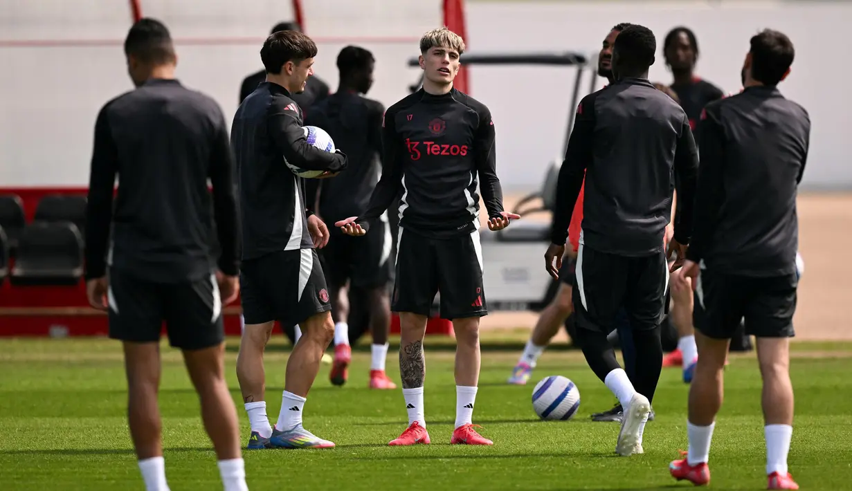 Gelandang Manchester United (MU) asal Argentina, Alejandro Garnacho (tengah) bereaksi saat mengikuti sesi latihan tim di Carrington Training Complex, Manchester, Inggris pada 14 Mei 2025. (Oli SCARFF/AFP)
