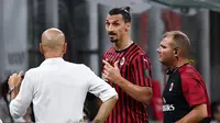 Pelatih AC Milan, Stefano Pioli, berusaha menenangkan Zlatan Ibrahimovic yang kecewa usai diganti saat melawan Bologna pada laga Serie A di Stadion San Siro, Sabtu (18/7/2020). AC Milan menang dengan 5-1 atas Bologna. (AFP/Marco Bertorello)