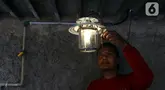 Para pekerja menyalakan lampu berbahan bakar biogas yang mengubah kotoran sapi menjadi gas untuk keperluan rumah tangga, Selasa (12/12/2023) di kawasan Pancoran, Jakarta.  (Liputan6.com/Herman Zakharia)