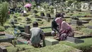 Sejumlah umat muslim membesihkan makam keluarganya di Tempat Pemakaman Umum (TPU) Karet Tengsin, Jakarta, Minggu (27/3/2022). Sepekan jelang datangnya bulan suci Ramadan, banyak warga yang melakukan tradisi ziarah makam untuk mendoakan keluarganya. (Liputan6.com/Faizal Fanani)