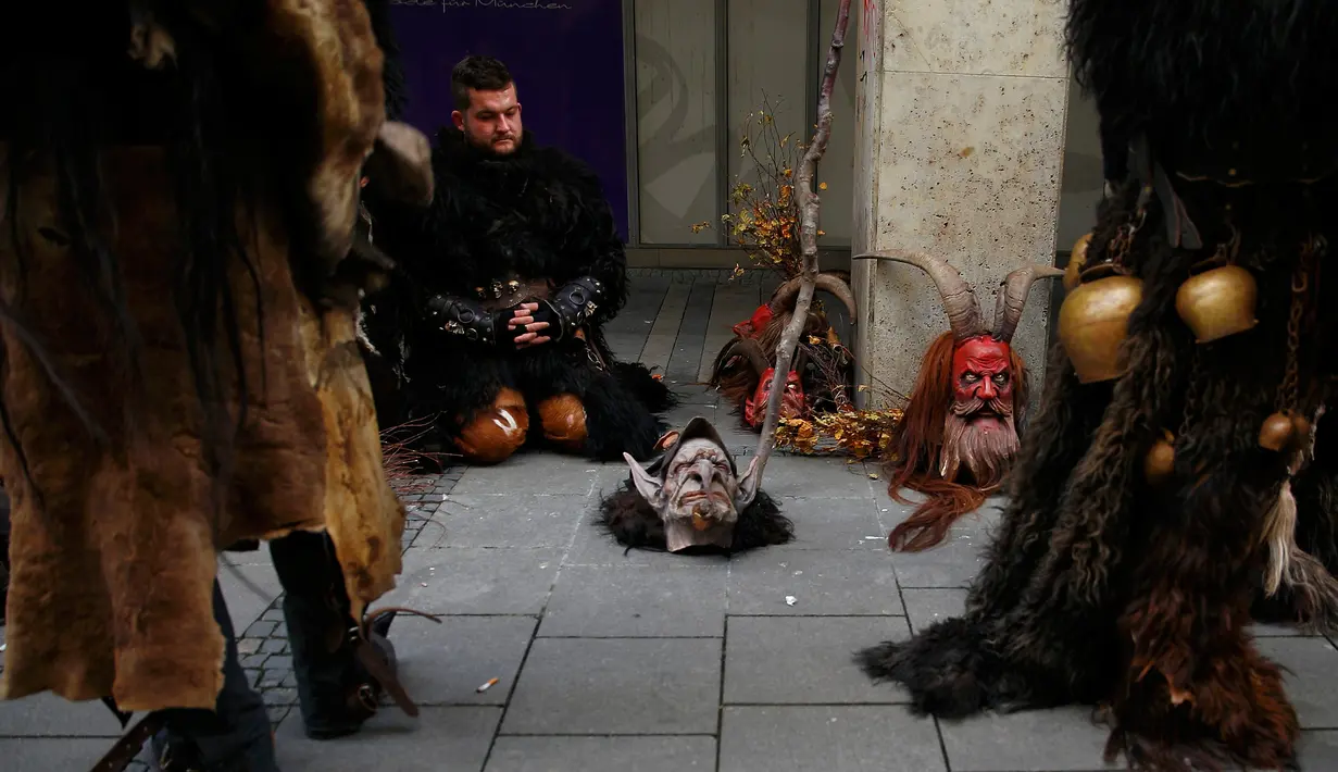 Seorang tampak beristirahat selama mengikuti parade di Munich, Jerman, Minggu (13/12). Krampuss diceritakan sebagai teman Saint Nicholas untuk datang ke rumah - rumah.  (REUTERS/Michael Dalder)