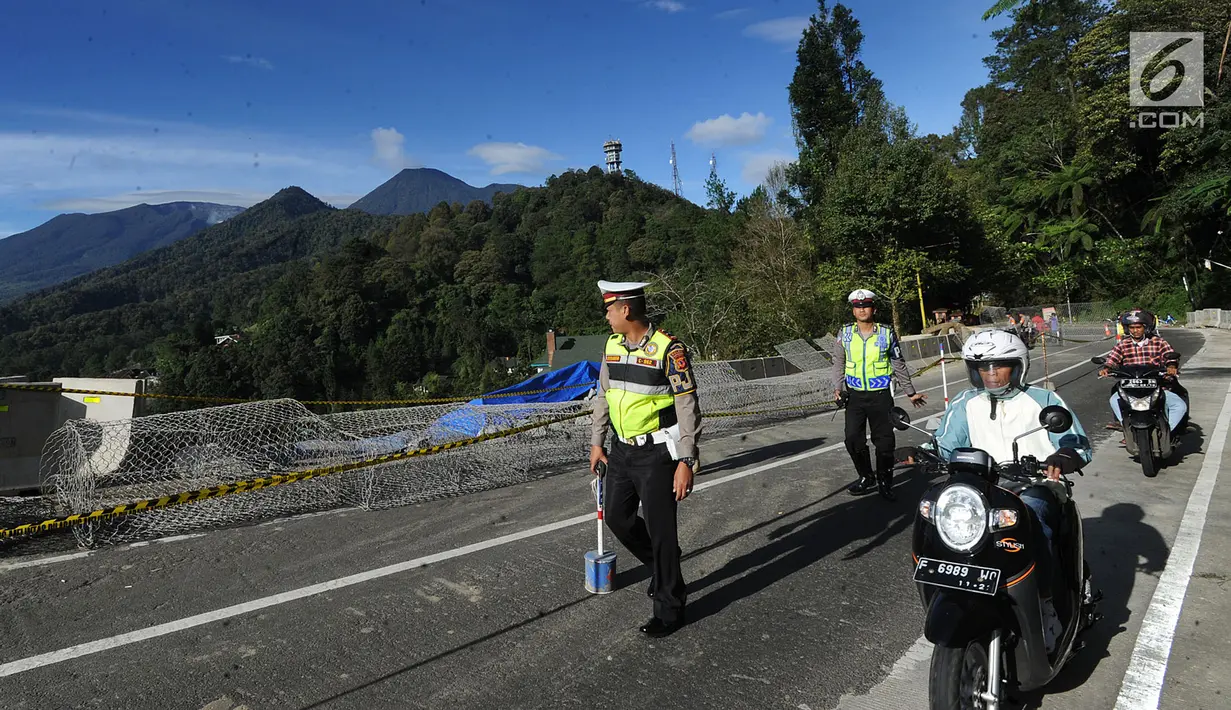 Pengendara motor melewati kawasan longsor di kawasan Ciloto, Cianjur, Jawa Barat, Kamis (29/3). Longsor di bahu Jalan Raya Puncak itu membuat arus lalu lintas ditutup sementara bagi pengendara roda empat. (Merdeka.com/Arie Basuki)