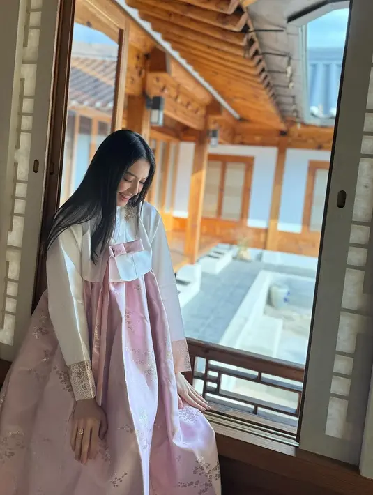 Raline Shah terlihat mengenakan hanbok berwarna putih dan pink yang bikin ia terlihat feminin. [@ralineshah]