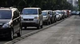 Tingginya minat masyarakat berwisata ke Monumen Nasional, Jakarta, (30/7/2014), membuat sejumlah ruas jalan yang ada di sekitar Tugu Monas berubah menjadi tempat parkir. (Liputan6.com/Johan Tallo)