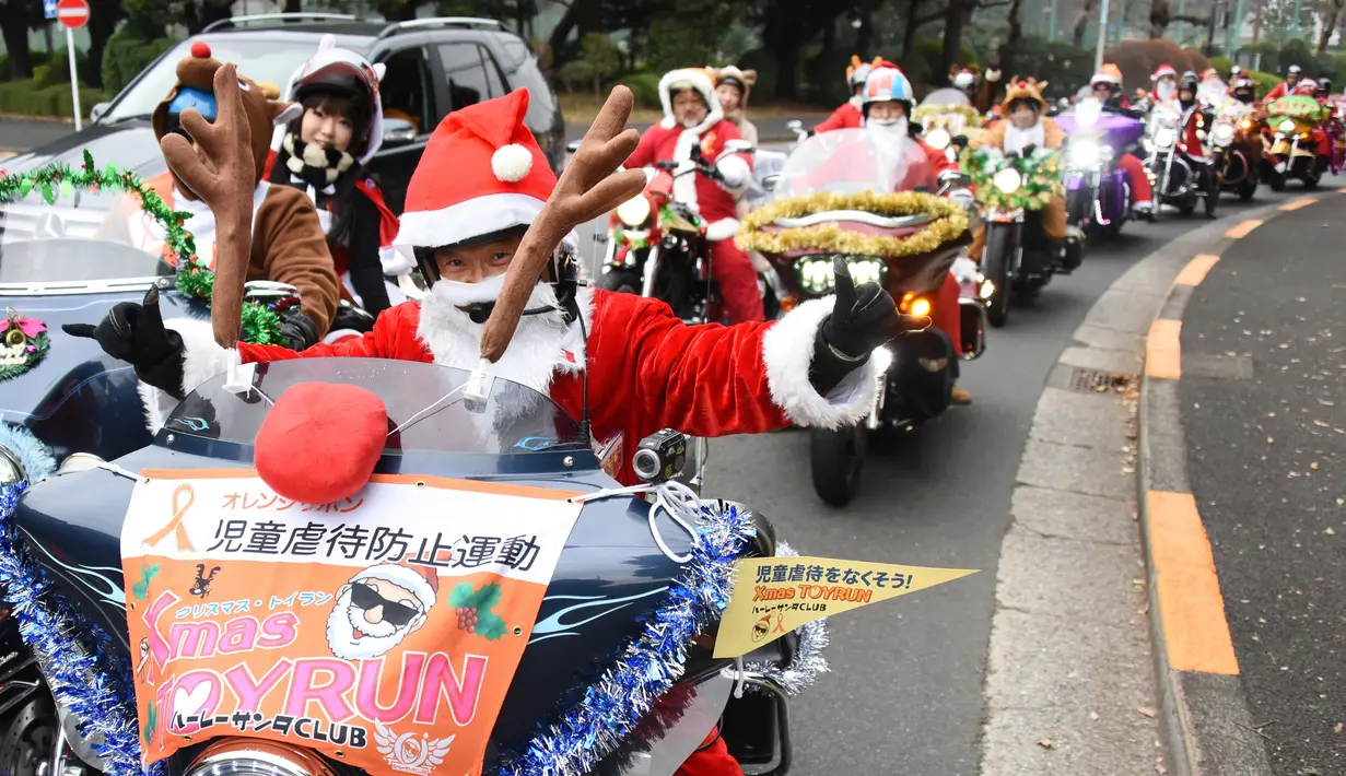 Sejumlah pengendara motor gede mengenakan kostum Santa Claus dan rusa di kota Tokyo, Jepang, (23/12). Sekitar 500 pengendara Harley mengikuti touring ini. (AFP PHOTO/Toru Yamanaka)