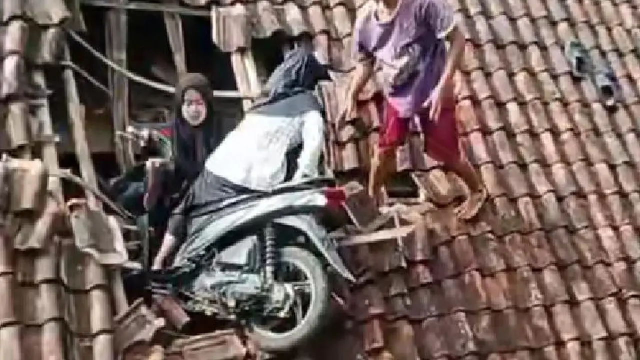 Dua remaja nyangkut di atas rumah warga