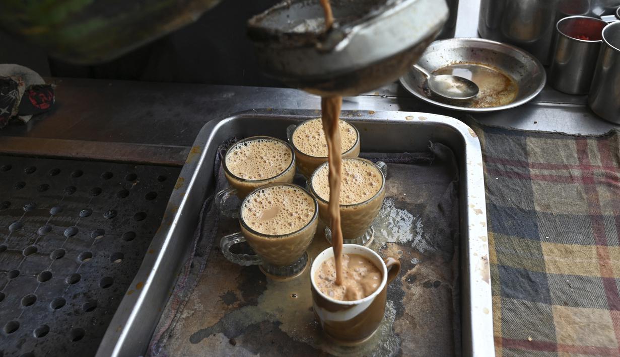 <p>Seorang pekerja menuangkan cangkir teh untuk pelanggan di sebuah restoran di Islamabad, Pakistan, Rabu (15/6/2022). Permintaan untuk mengurangi minum teh menjadi viral di media sosial. Banyak yang meragukan masalah keuangan negara yang serius dapat diatasi dengan menghentikan minuman berkafein tersebut. (Aamir QURESHI / AFP)</p>