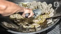 Pekerja menggoreng kerupuk saat produksi rutin di industri rumahan kawasan Cipinang Melayu, Jakarta, Selasa (16/2/2021). Pemilik industri kerupuk rumahan ini berharap Covid-19 segera berakhir agar industri kerupuk yang dirintis turun-temurun itu dapat normal kembali. (merdeka.com/Iqbal S Nugroho)