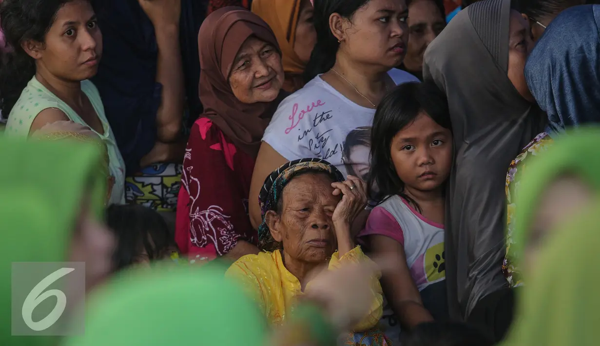 Warga mengantri untuk membeli kebutuhan pokok dalam Pasar Murah Ramadan di Mesjid Jami Luar Batang, Jakarta, Kamis (9/7/2015). Pasar Murah Ramadan dimulai dari 29 Juni - 16 Juli 2015. (Liputan6.com/Faizal Fanani)
