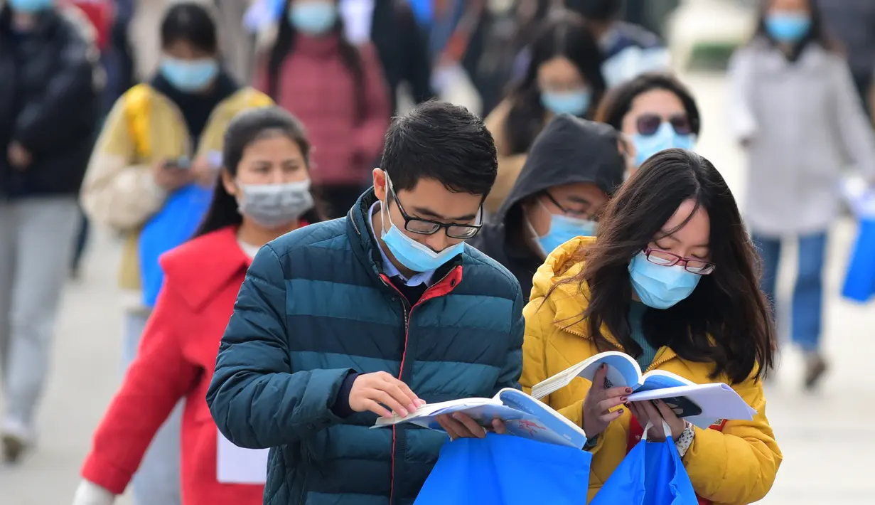 Para peserta mempelajari materi pelajaran sembari menunggu untuk mengikuti ujian pegawai negeri sipil (PNS) nasional China di sebuah sekolah di Kota Wuxi, Jiangsu, China pada 29 November 2020. Ujian PNS nasional China untuk angkatan 2021 diadakan di seluruh penjuru negeri itu. (Xinhua/Xuan Yueliang)