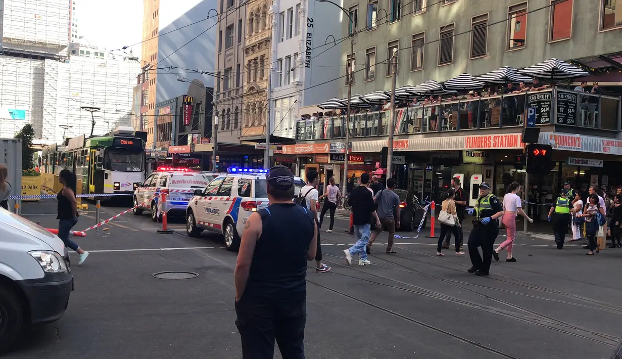 Kendaraan polisi terparkir di lokasi mobil menabrak kerumunan pejalan kaki di kawasan pusat bisnis Melbourne, Australia, Kamis (21/12). Menurut saksi mata, mobil itu menerobos lampu merah sebelum menabrak pejalan kaki. (Australian Broadcast Corp. via AP)