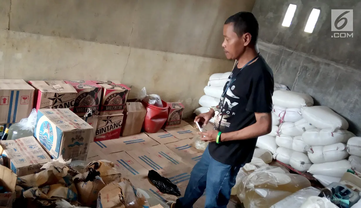Seorang pria memeriksa barang bukti minuman keras Cap Tikus di Polres Gorontalo, Kamis, (24/1). Sebanyak 1,5 ton Cap Tikus dalam kantong plastik diselundupakan dalam karung. (Liputan6.com/Arfandi Ibrahim)
