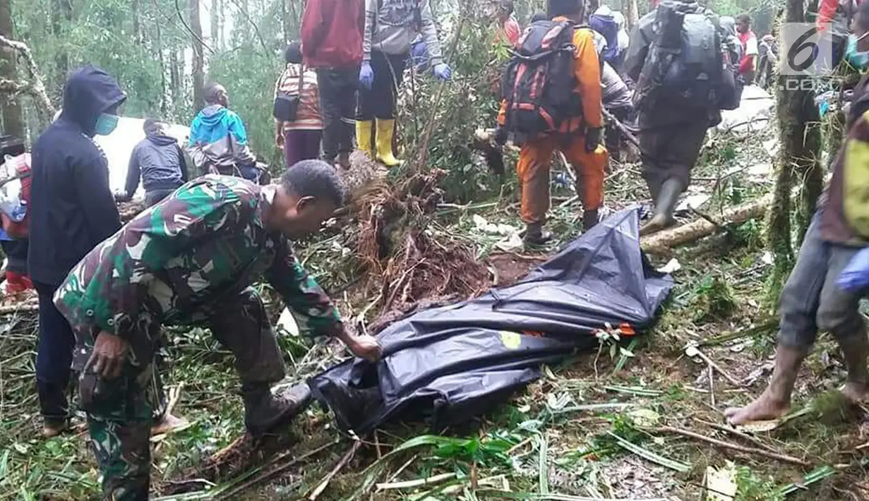Personel TNI memegang kantung jenazah dekat pesawat Dimonim PK-HVQ yang jatuh di Kabupaten Pegunungan Bintang, Papua, Minggu (12/8). Korban selamat atas nama Jumadi (12) mengalami luka patah pada tangan sebelah kanan. (Liputan6.com/HO/Humas Polda Papua)