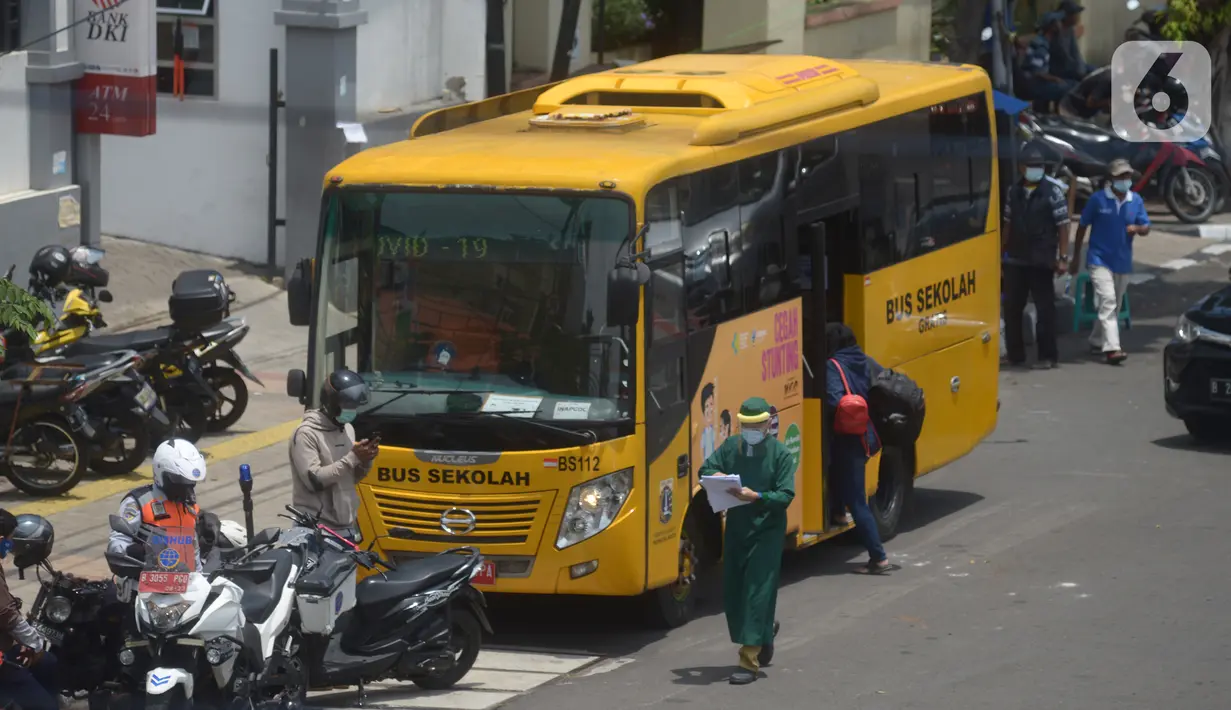 Bus sekolah menjemput pasien Covid-19 berstatus orang tanpa gejala (OTG) di Puskesmas Jatinegara, Jakarta, Selasa (22/9/2020). Sejumlah unit bus sekolah kini dialihfungsikan menjadi kendaraan untuk mengantar pasien Covid-19 berstatus OTG menuju RS Darurat Wisma Atlet. (merdeka.com/Imam Buhori)