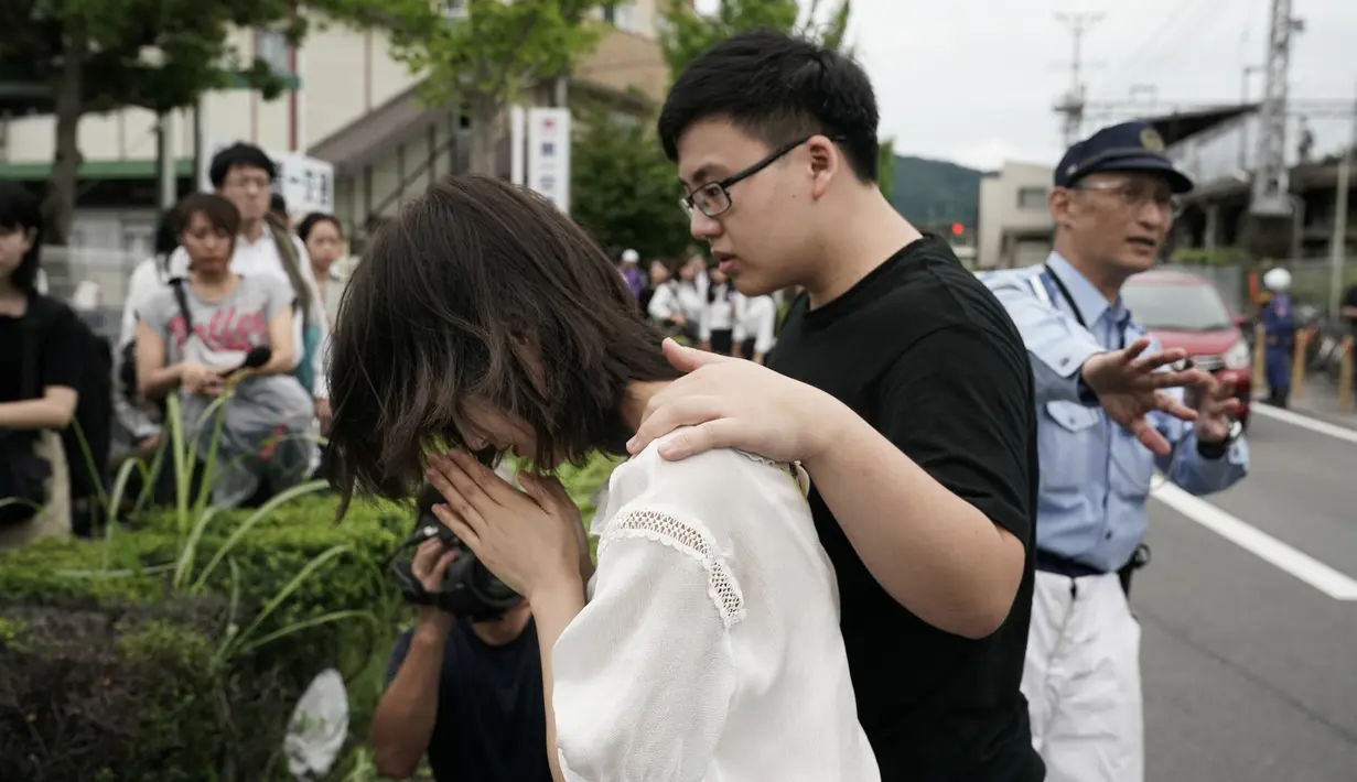 Seorang wanita berdoa untuk para korban kebakaran  di gedung Kyoto Animation Studio di Kyoto, Jepang (19/7/2019). Pihak kepolisian masih menyelidiki penyebab kebakaran, namun polisi menduga kebakaran tersebut atas unsur kesengajaan. (AP Photo/Jae C. Hong)