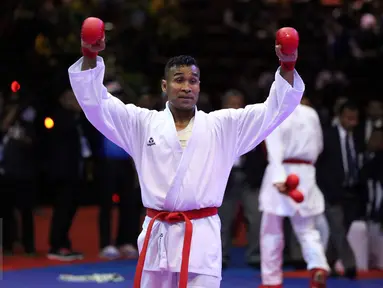 Karateka Jawa Timur, Umar Syarief mengangkat tangan usai menumbangkan Caesar George (Jakarta) di kelas Kumite Individu Putra +84 kg senior PON XIX di Sabuga, Bandung, Minggu (18/9). Umar menang telak 9-1 atas Caesar. (Liputan6.com/Helmi Fithriansyah)