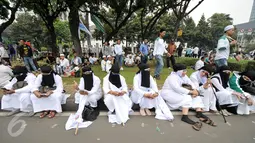 Sejumlah demonstran perempuan beristirahat di pinggir taman Jalan Medan Merdeka Selatan, Jumat (4/11). Ratusan ribu massa aksi damai melakukan aksi menuntut penegakan hukum kasus dugaan penistaan agama. (Liputan6.com/Yoppy Renato)