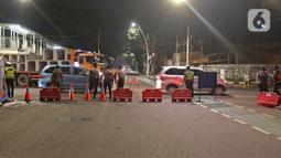 Polisi berjaga di Jalan Gunawarman, Jakarta, Senin (21/6/2021). Penutupan jalan dalam rangka pembatasan mobilitas warga guna menekan penyebaran COVID-19 dilakukan mulai pukul 21.00 WIB hingga 04.00 WIB di 10 titik di Kota Jakarta. (Liputan6.com/Herman Zakharia)