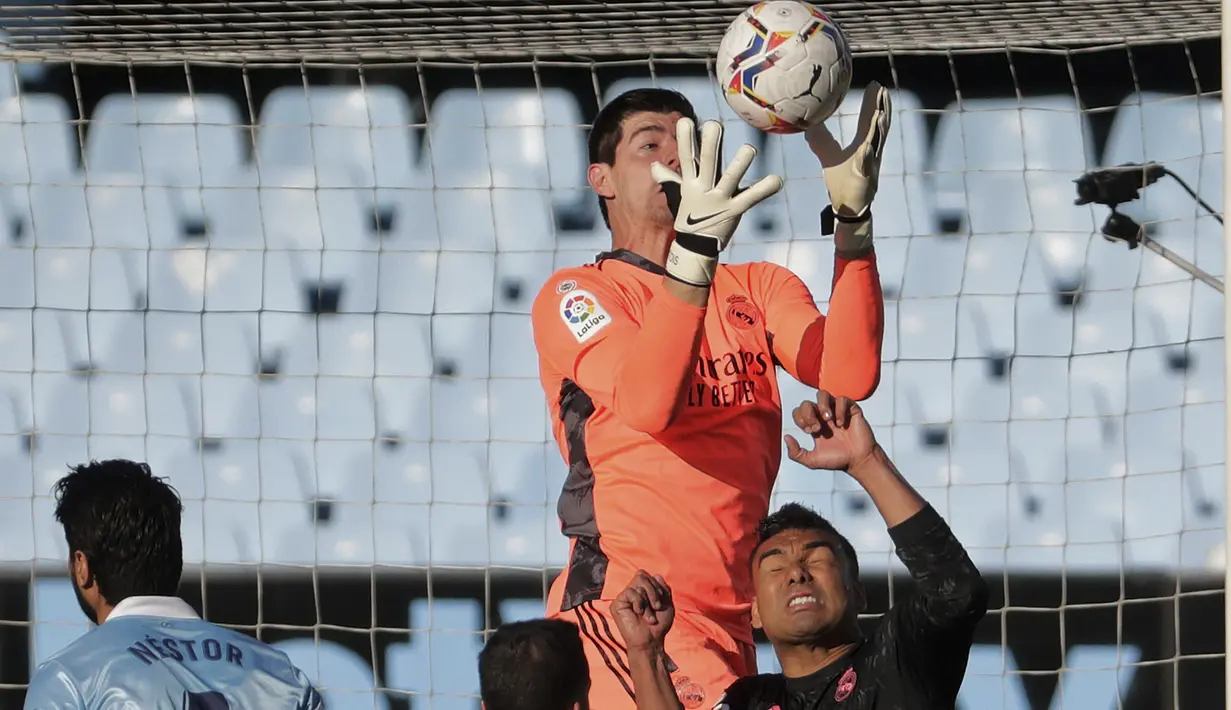 Kiper Real Madrid, Thibaut Courtois melompat untuk menangkap bola saat menghadapi Celta Vigo dalam laga lanjutan Liga Spanyol 2020/2021 pekan ke-28 di Balaidos Stadium, Sabtu (20/3/2021). Real Madrid menang 3-1 atas Celta Vigo. (AP/Lalo R. Villar)