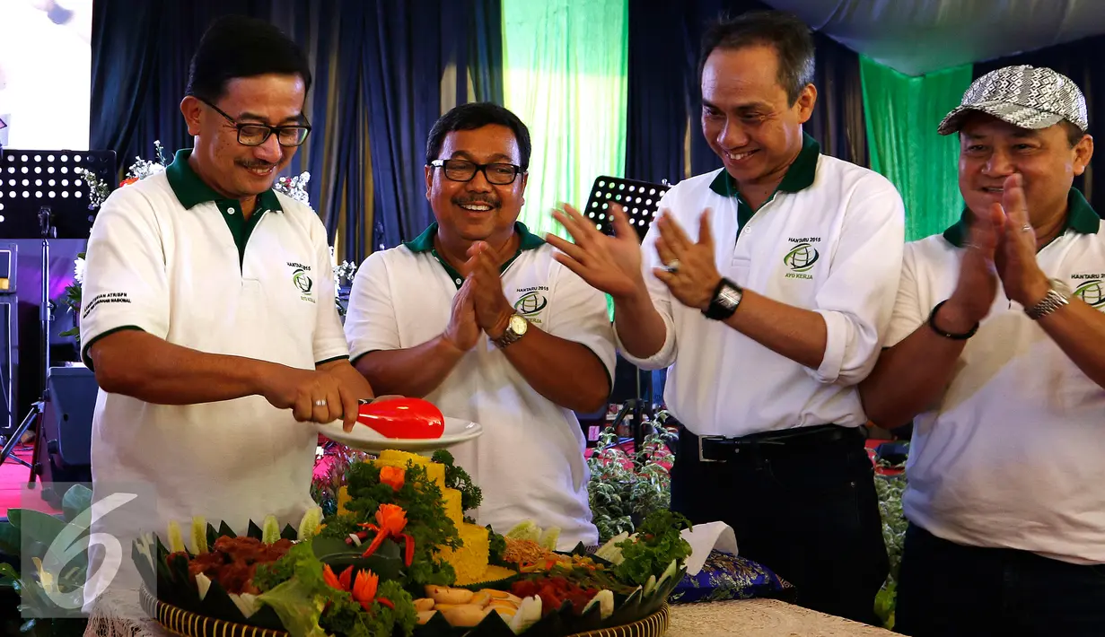Menteri Agraria dan Tata Ruang, Ferry Musyidan Baldan melakukan pemotongan tumpeng sebagai tanda peringatan Hari Agraria Nasional di kantor Kementerian ATR/BNP, Jakarta, Minggu (27/9/2015). (Liputan6.com/Yoppy Renato)