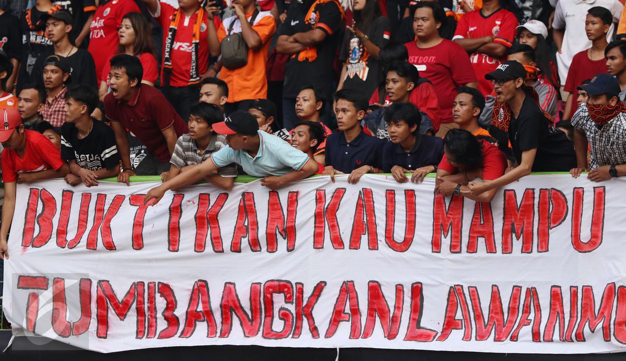Suporter membentangkan spanduk protes usai menyaksikan laga Persija melawan Mitra Kukar pada lanjutan Liga 1 Indonesia di Stadion Patriot Candrabhaga, Bekasi, Minggu (14/5). Laga kedua tim berakhir imbang 1-1. (Liputan6.com/Helmi Fithriansyah)