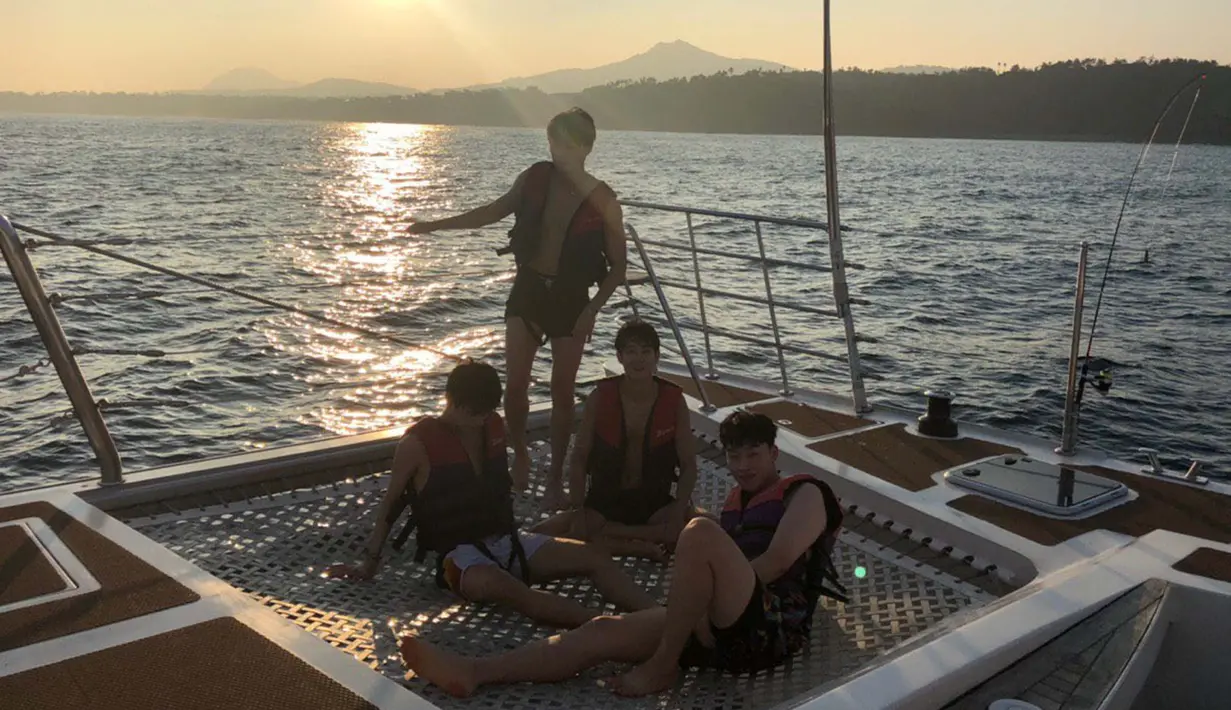 Keempat sahabat ini menaiki kapal sambal menikmati sunset di tengah laut. (Liputan6.com/Twitter/@BTS_twt)