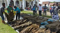 Warga melihat jenazah korban tsunami dan gempa 2004 di Kajhu, Aceh (19/12). Sekitar 30 jenazah korban tsunami Aceh dan gempa bumi ditemukan penduduk desa dekat lokasi konstruksi kompleks perumahan yang baru dibangun. (AFP Photo/Chaideer Mahyuddin)