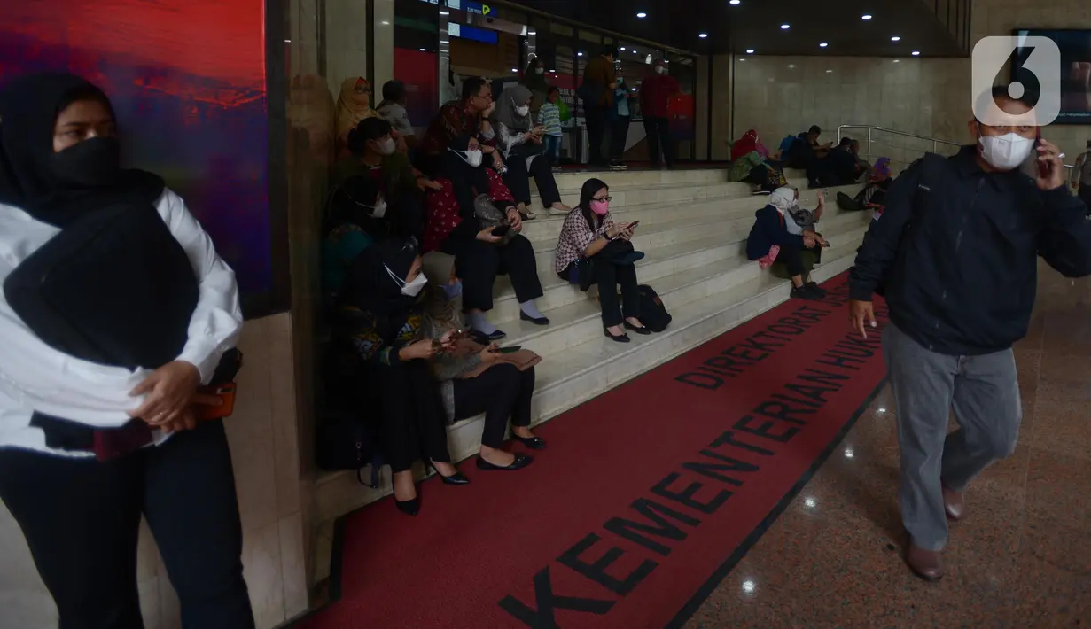 Pegawai berhamburan di luar Gedung Kemenkumham saat terjadi kebakaran, Jakarta, Kamis (8/12/2022). Ada 26 unit mobil dan 130 personel pemadam yang dikerahkan untuk memadamkan api di lokasi. (merdeka.com/Imam Buhori)