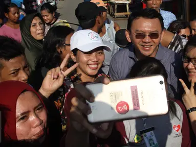 Warga foto bersama Cagub DKI Jakarta Basuki T Purnama (Ahok) saat kampanye blusukan di kawasan Koja, Jakarta, Jumat (24/3). Ahok mengunjungi warga lansia yang sedang sakit dan menawarkan untuk menunaikan ibadah haji. (Liputan6.com/Gempur M Surya)