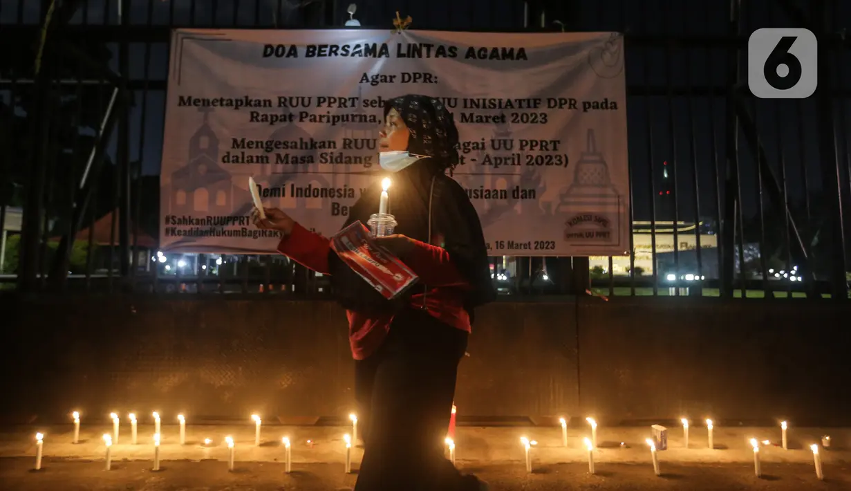 Massa menggelar aksi dengan membawa lilin dan doa bersama lintas agama di depan Gedung DPR, Jakarta, Kamis (16/3/2023). Dalam aksinya, mereka menuntut agar pimpinan DPR menetapkan RUU PPRT sebagai RUU INISIATIF DPR di Rapat Paripurna pada Selasa, 21 Maret 2023 mendatang. (Liputan6.com/Johan Tallo)