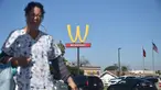 Seorang wanita berjalan dengan latar belakang plang logo restoran cepat saji McDonald's yang terbalik di Lynwood, California (8/3). Huruf W tersebut merupakan inisial untuk women atau wanita. (AFP Photo/Frederic J. Brown)