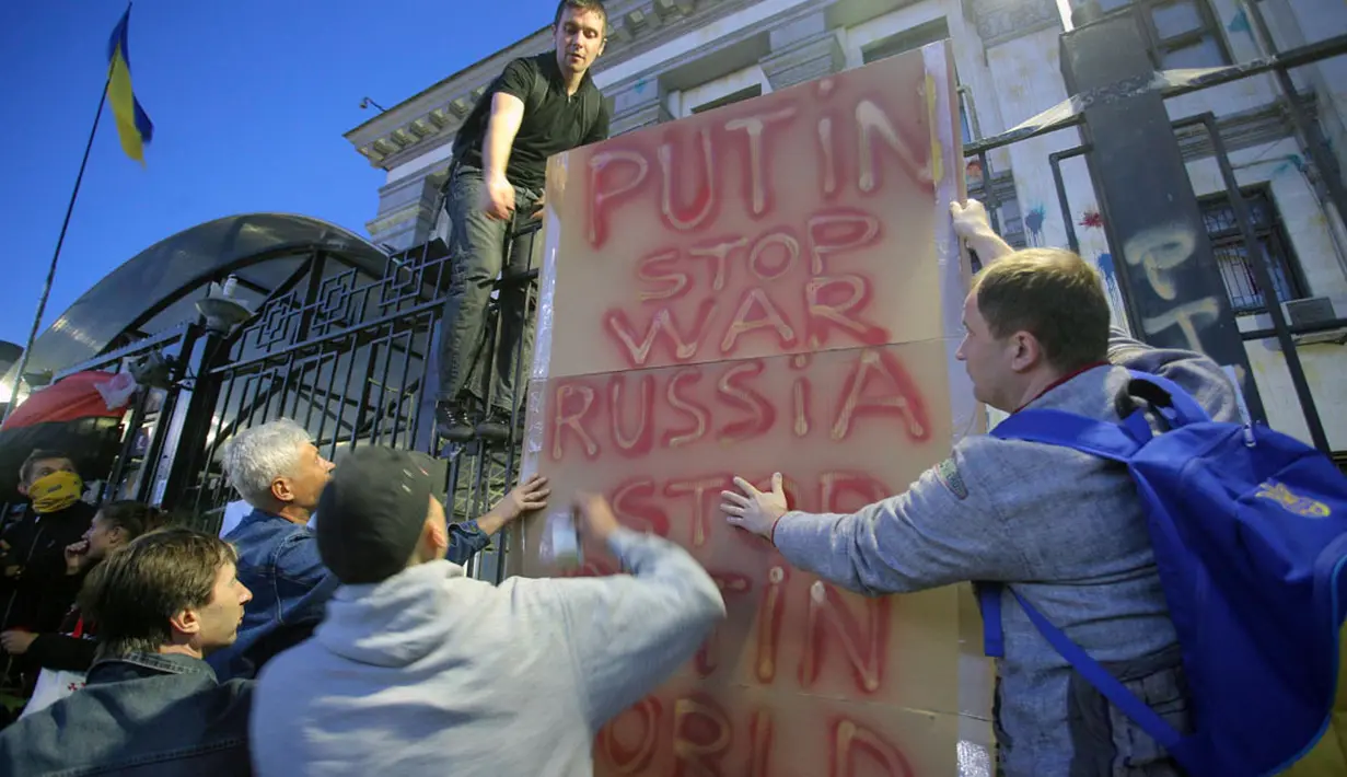 Para pengunjuk rasa mendirikan sebuah plakat saat berunjuk rasa di depan gedung Kedutaan Besar Rusia di Kiev, Ukraina, (14/6/2014). (REUTERS/Oleg Pereverzev)