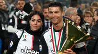Striker Juventus, Cristiano Ronaldo bersama kekasihnya Georgina Rodriguez berpose bersama Piala Liga Italia Serie A usai menjuarainya untuk ke-33 kalinya di Stadion Allianz, Turin (19/5/2019). (AP Photo/Antonio Calanni)